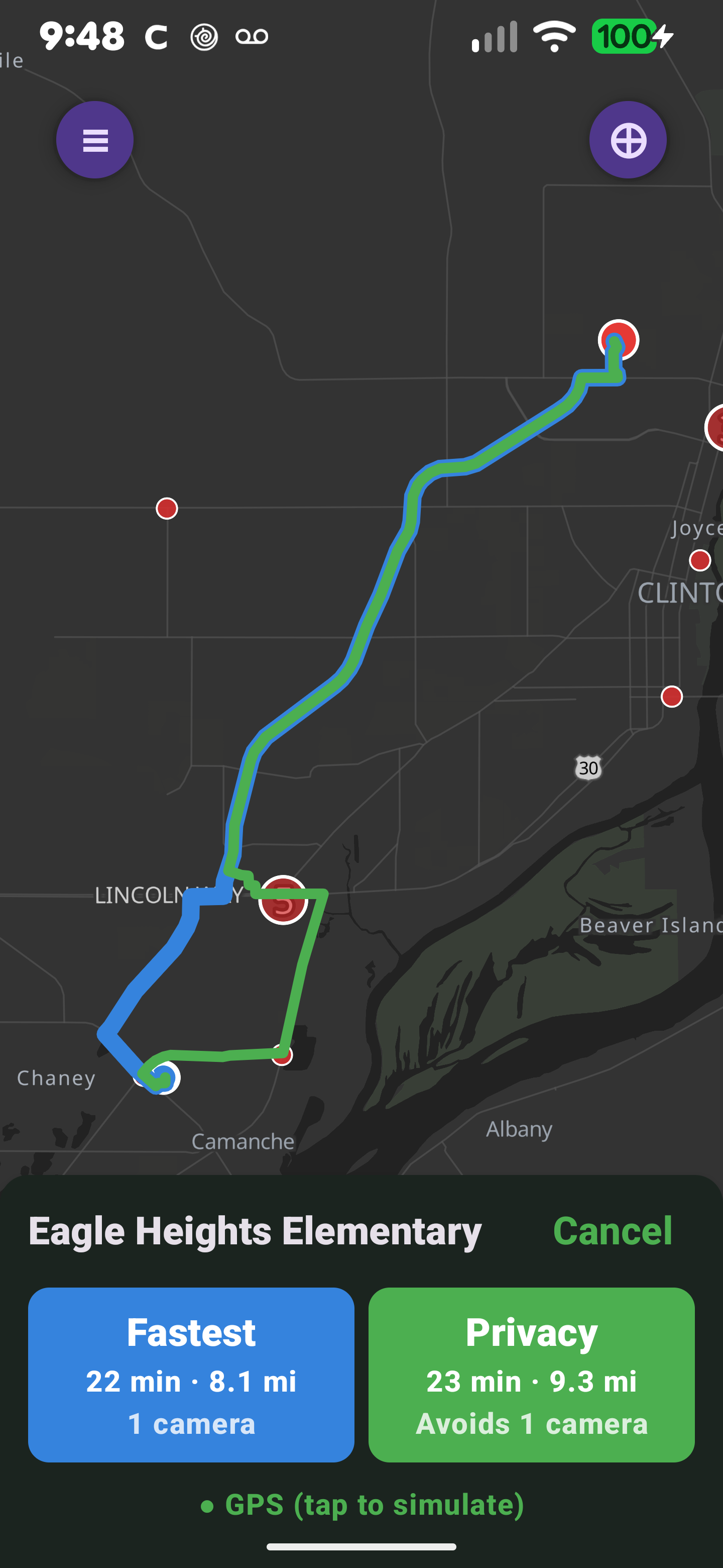 RedactedRoute app showing a route to Eagle Heights Elementary: a dark navigation map with red ALPR camera markers, the blue fastest route and the green privacy route diverging around a camera, and a bottom sheet comparing the two — Fastest 22 min · 8.1 mi · 1 camera, Privacy 23 min · 9.3 mi · Avoids 1 camera.